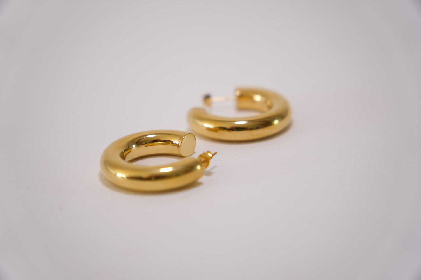 Chunky gold tube hoop earring worn on ear, 18k gold plated stainless steel, Mac&Coco South Africa
