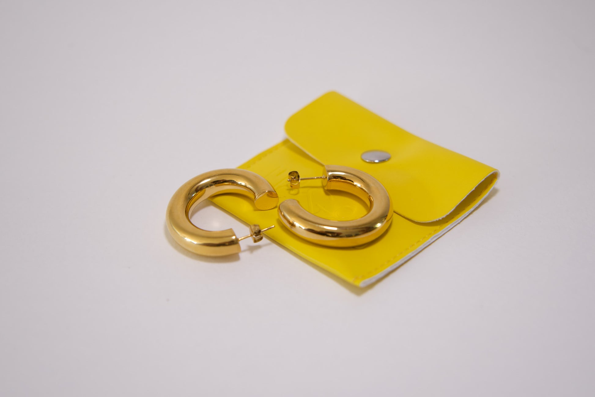 Chunky gold tube hoop earring worn on ear, 18k gold plated stainless steel, Mac&Coco South Africa