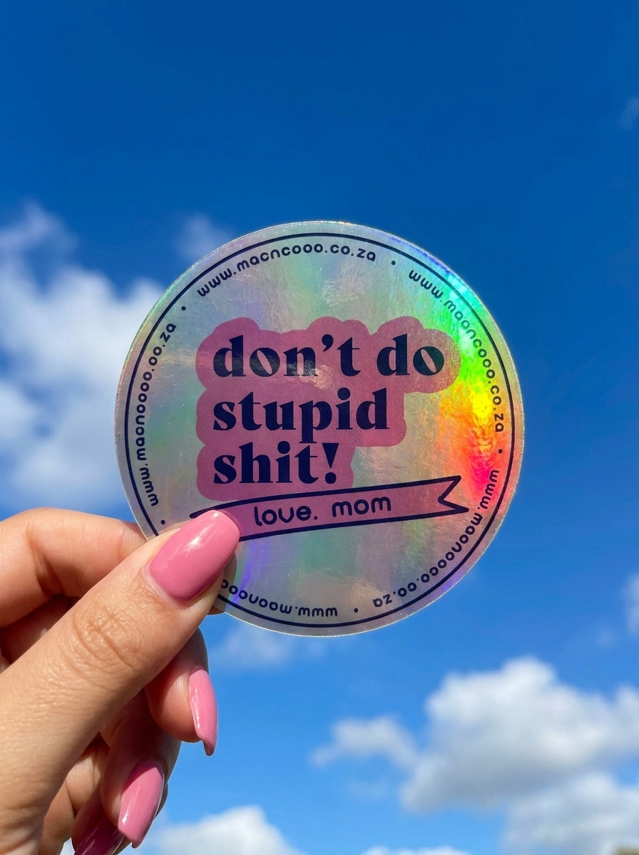 Holographic licence disc sticker held against blue sky